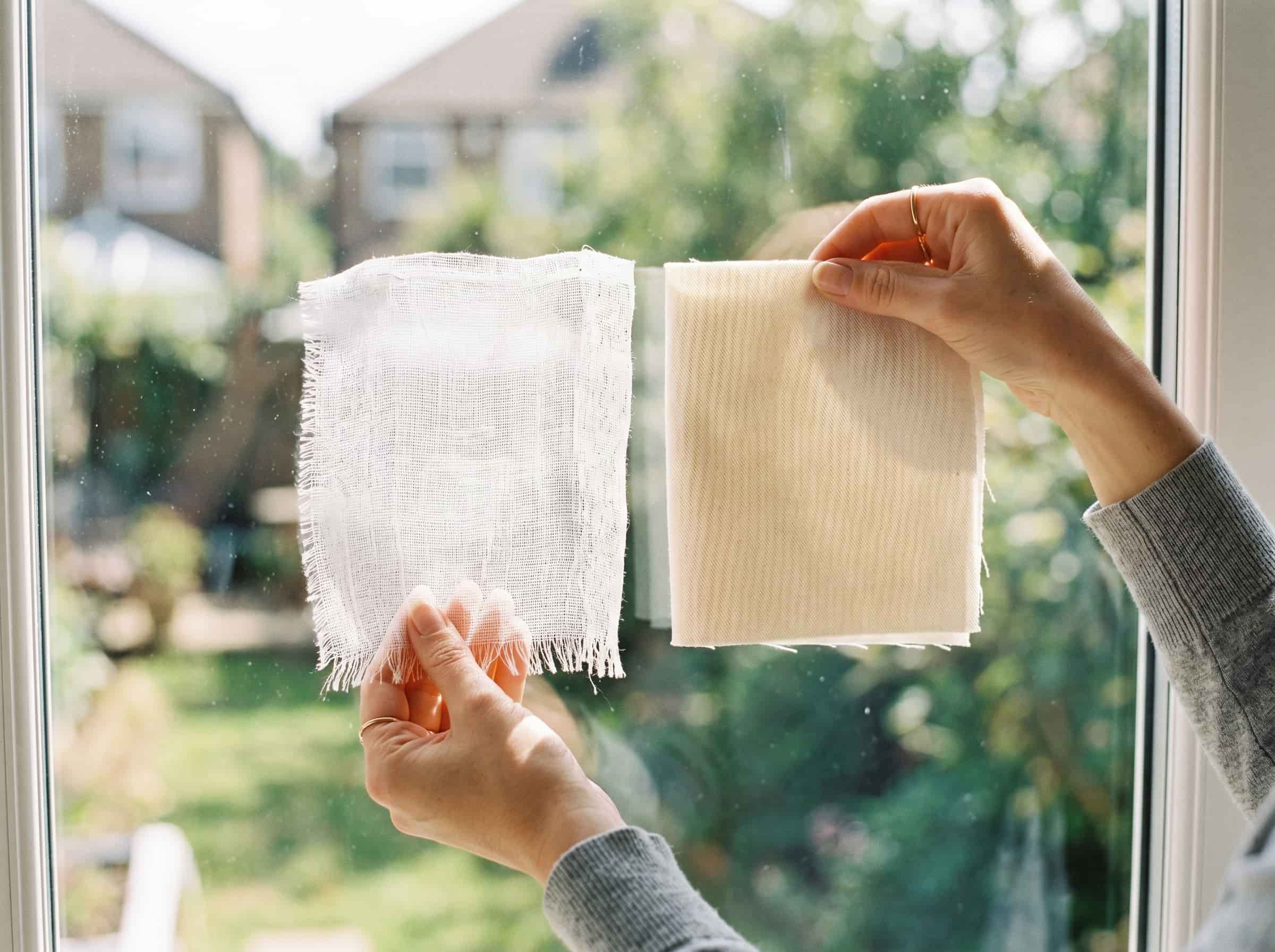 Fabric quality test sheer versus opaque cotton Polished Intent Hands holding thin sheer fabric and dense cotton fabric up to natural light for comparison.